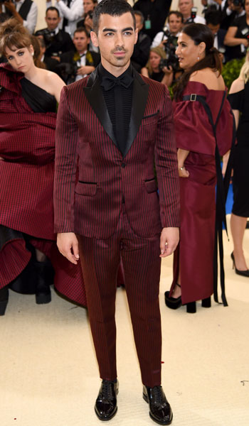 Joe Jonas vistió un traje ajustado en un intenso color rojo confeccionado en satén de seda doble con rayas y solapas negras, también de H&M